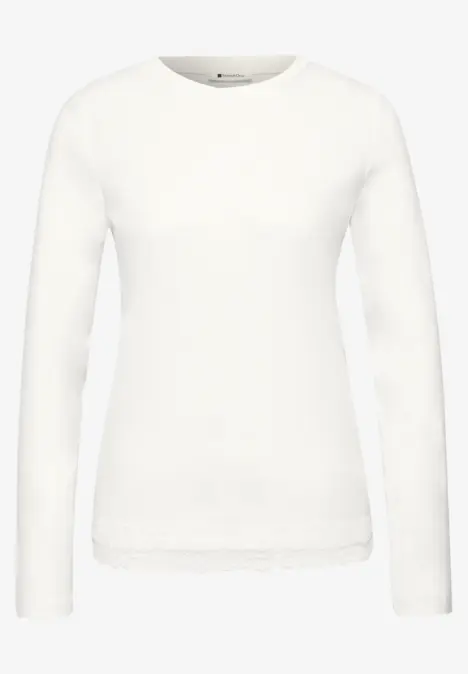 Wit langarig shirt met ronde hals en kanten rand langs de zoom.