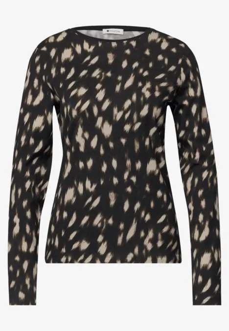 T-shirt noir à manches longues avec motif abstrait beige à pois et encolure ronde.