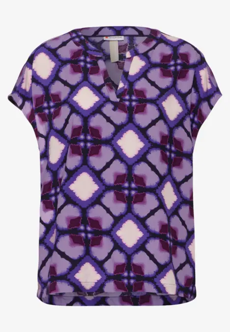 Lila Bluse mit abstraktem Muster und kurzen Ärmeln.