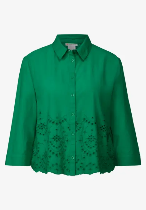 Grüne Bluse mit Knopfleiste und Lochstickerei am Saum.