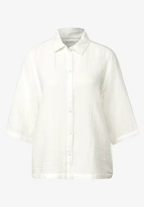 Weiße Bluse mit Knopfleiste und Dreiviertelärmeln.