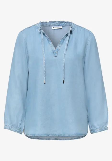 Hellblaue Jeansbluse mit V-Ausschnitt und Bindebändern, langärmelig und lockerer Schnitt.