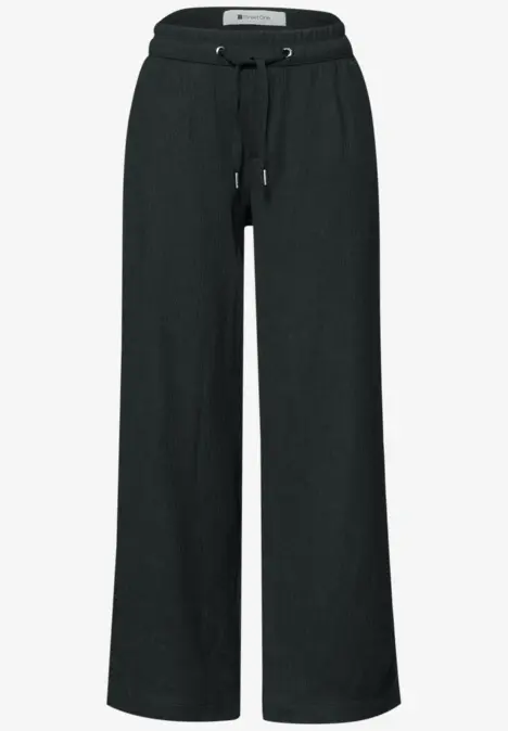 Schwarze, locker geschnittene Hose mit weitem Bein und elastischem Bund samt Kordelzug.