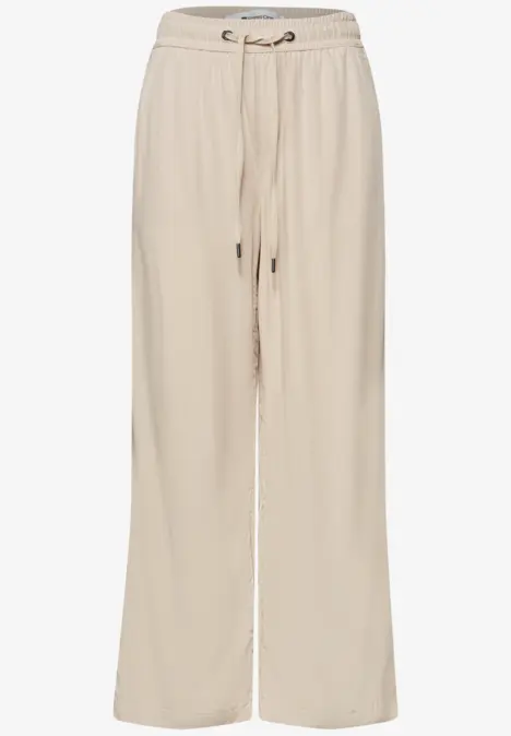 Beige weite Leinenhose mit Kordelzugbund und seitlichen Taschen.