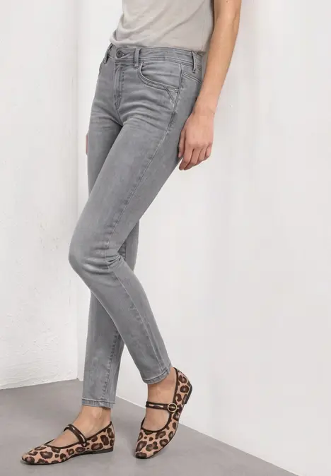 Graue Skinny-Jeans und leo-gemusterte Riemchensandalen.