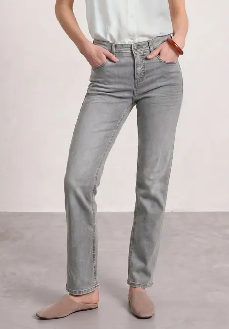 Graue, gerade geschnittene Jeans mit beigen Slippern und weißem Oberteil – schlicht und zeitlos.