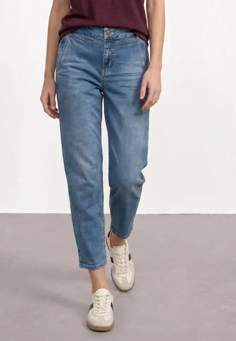 Jeans met mid-rise en rechte pijpen, gecombineerd met beige sneakers.
