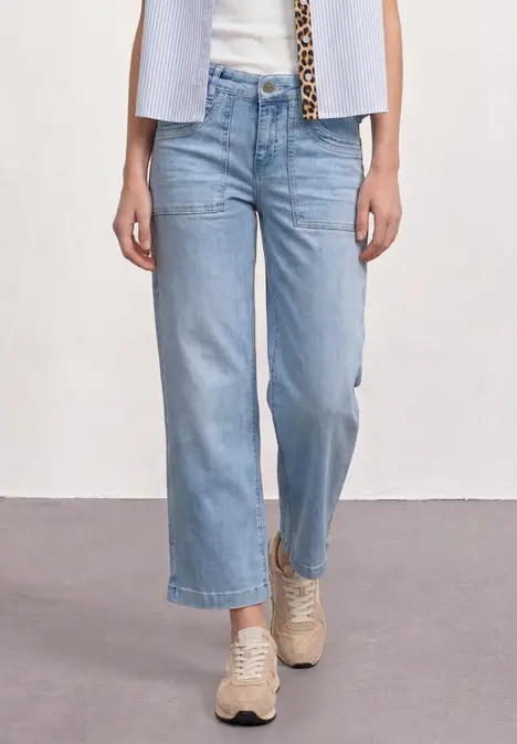 weiche, weite hellblaue 7/8-Jeans mit beigen Sneakers.