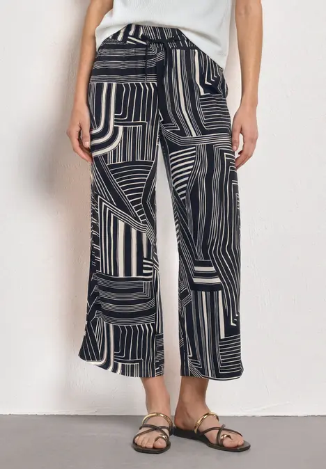 Schwarze, weiße Hose mit weitem Schnitt und grafischem Muster.