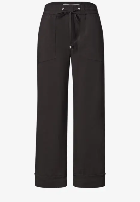 Schwarze, weite Hose mit Tunnelzugbund und aufgesetzten Taschen.