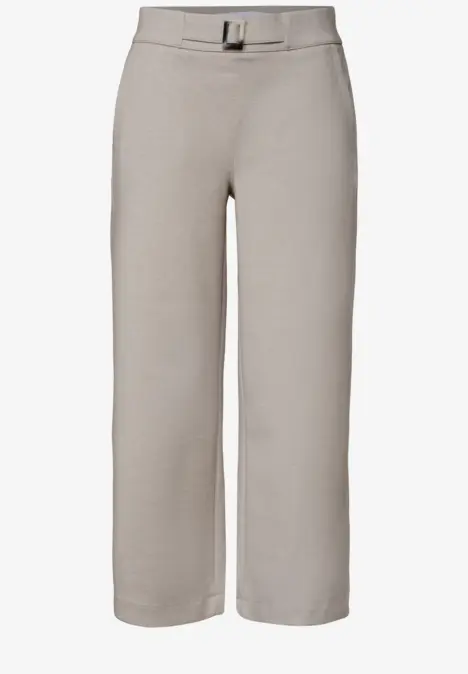 Pantalon ample beige clair à la cheville, taille haute, plis à l'avant et ceinture assortie.