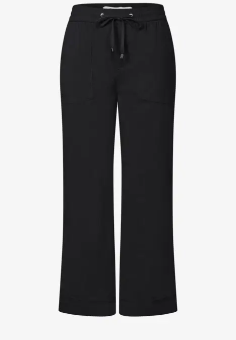 Schwarze, weite Hose mit elastischem Bund und Kordelzug, zwei aufgesetzte Taschen vorne.