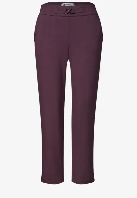 Bordeauxrote Hose mit Bügelfalte, schmalem Gürtel und geradem Schnitt, knöchellang.