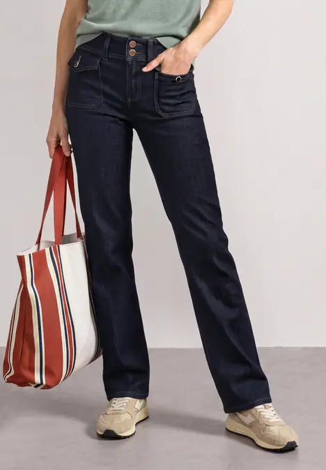 Ciemne dżinsy, beżowe trampki, paskowany shopper i jasny zielony T-shirt – luźny look.