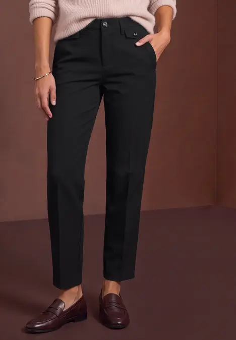 Schwarze, knöchellange Hose mit geradem Schnitt, kombiniert mit braunen Loafern.