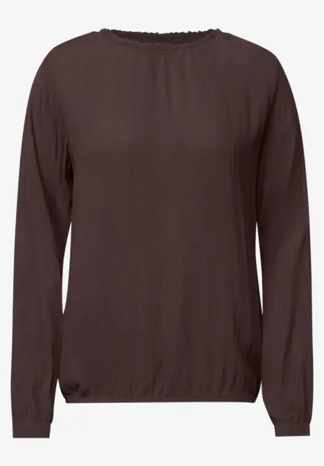Blouse marron à manches longues et encolure ronde, coupe légèrement cintrée.