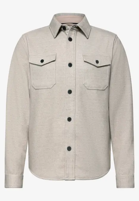 Hellbeige Hemdjacke mit Knopfleiste, Kentkragen und zwei aufgesetzten Brusttaschen.