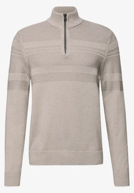 Beiger Strickpullover mit hohem Stehkragen und halbem Reißverschluss, dezente Querstreifen an Brust und Ärmeln.