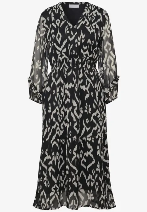 Schwarzes Kleid mit weißem, abstraktem Muster und langen Ärmeln.