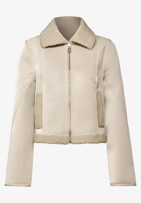 Kurze beige Lederjacke mit Reißverschluss und Fellkragen.