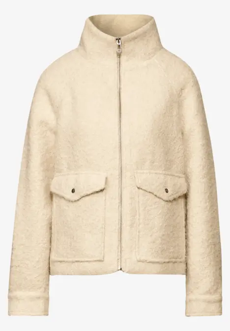 Beige Wolljacke mit Reißverschluss und zwei Fronttaschen.