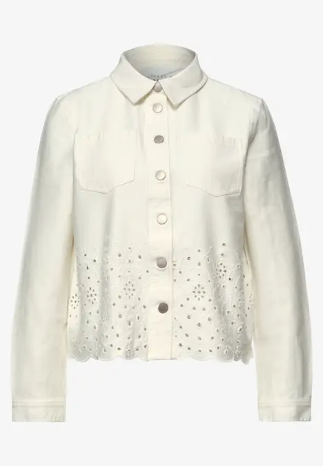 Veste-chemise blanche à boutons, poches poitrine et broderies ajourées au bas.