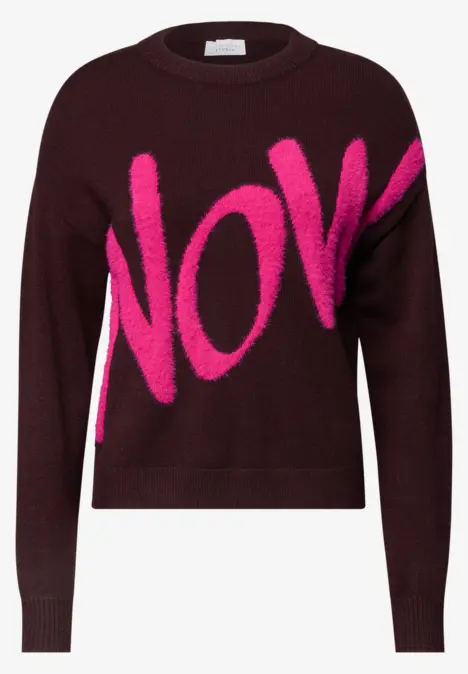 Dunkelroter Pullover mit auffälligem pinkfarbenem Schriftzug „NOW“.