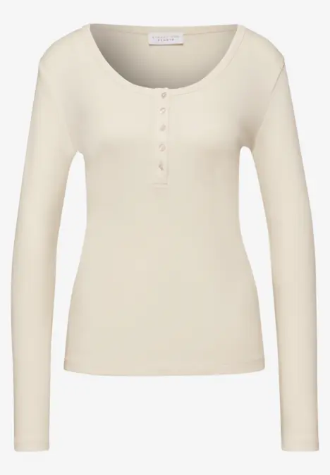Beiges Langarmshirt mit Knopfleiste am Ausschnitt.