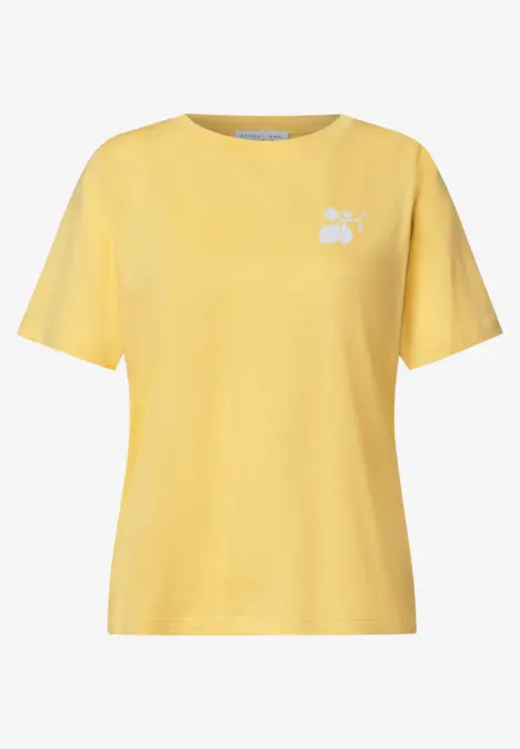 Un t-shirt jaune uni avec un petit motif floral blanc sur la poitrine.