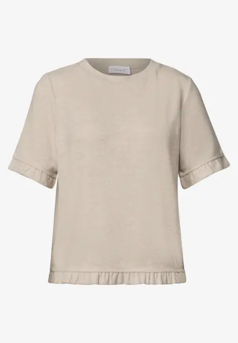 T-shirt court beige à manches courtes avec bord à volants discret.