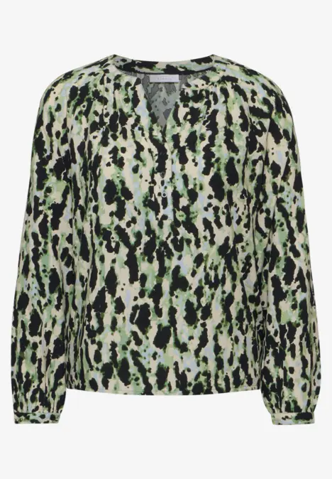 Langärmlige Bluse mit grün-schwarzem Fleckenmuster.