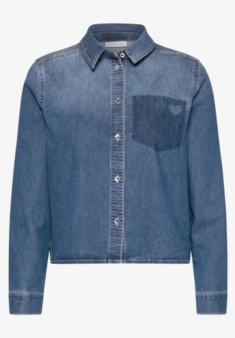 Une veste en jean décontractée à col chemise avec un cœur brodé sur la poche poitrine.