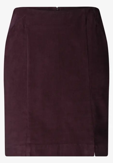 Jupe crayon en velours côtelé violet foncé, ajustée, longueur genoux avec fente latérale.