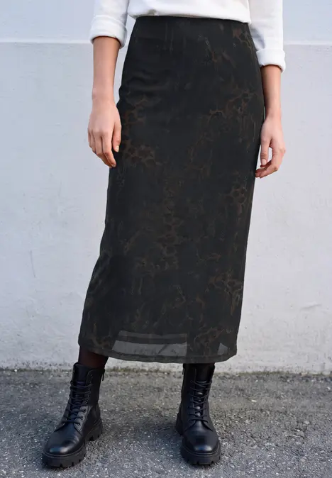 Schwarzer, leicht transparenter Midi-Rock mit dezentem Blumenmuster und schwarzen Schnürstiefeln.