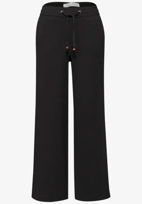 Schwarze, weit geschnittene Hose mit Kordelzug und elastischem Bund, lässiger Freizeitstil.