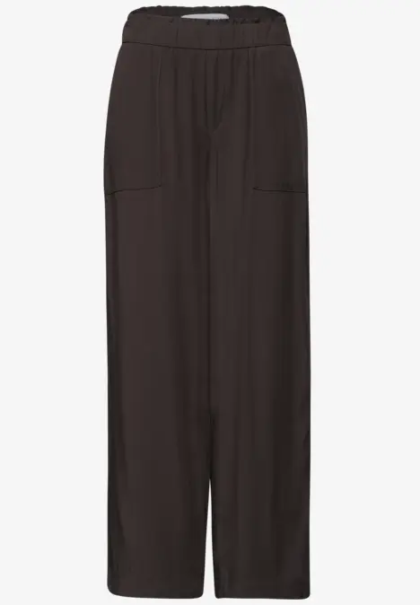 Zwarte, wijde broek met elastische taille en voorzakken.