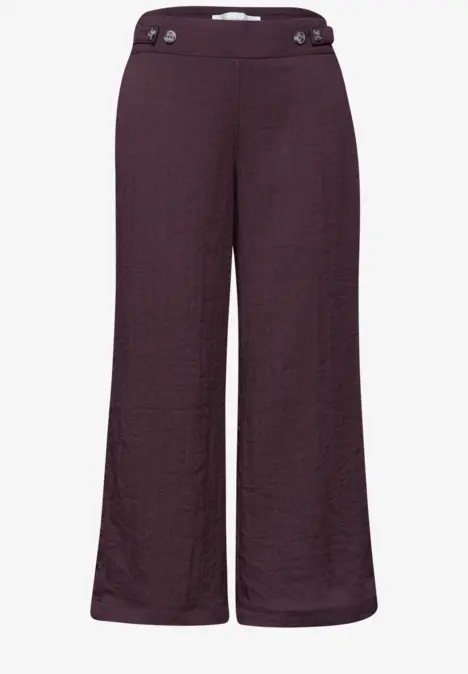 Dunkelviolette, weit geschnittene Damenhose mit hohem Bund und Knopfdetails.