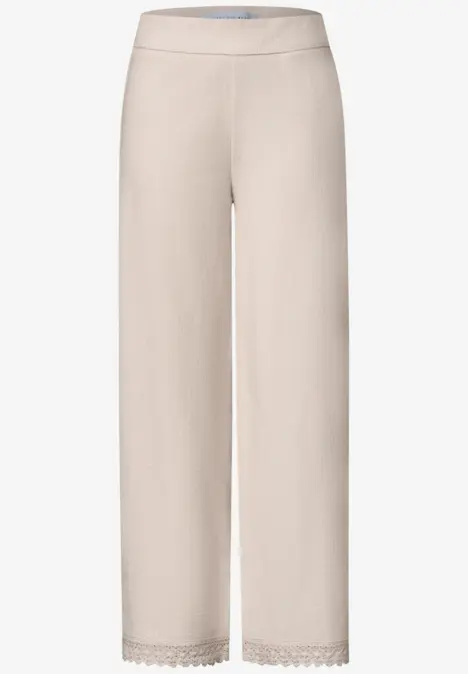 Bequeme, hellbeige Hose mit weitem Schnitt und zarter Spitzenbordüre am Saum